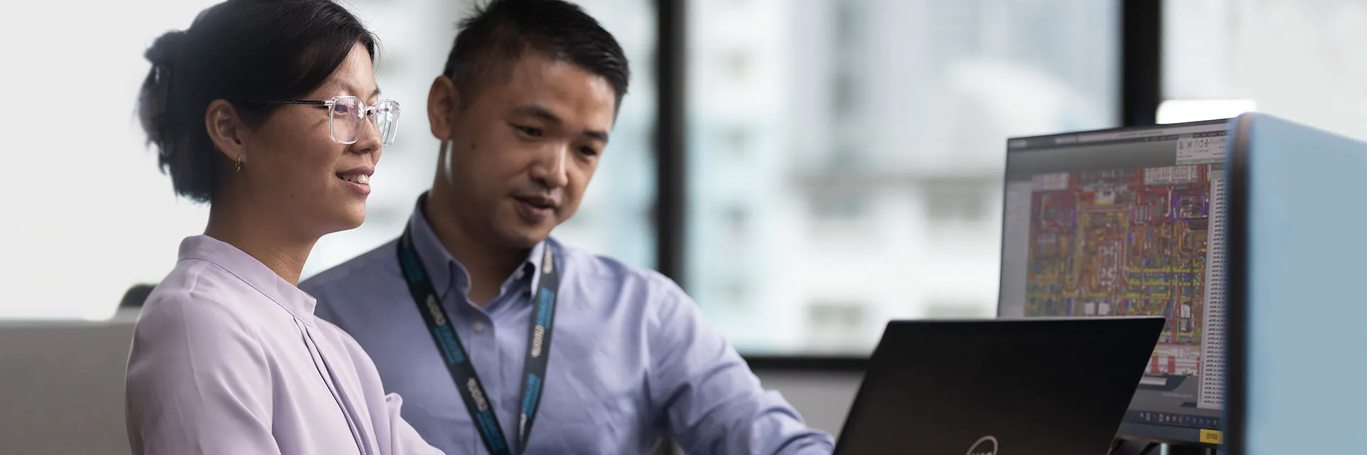 Two BEUMER electrical engineers in Singapore look at computer